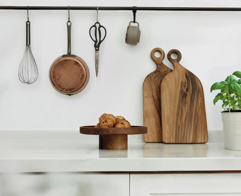 Moderne Küche mit Holzelementen, Kupferpfanne und Schneidebrettern aus Holz, stilvolle Küchendeko im natürlichen skandinavischen Design.